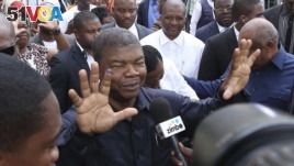 Joao Lourenco, shows his ink-stained finger as he faces the media after casting his vote in elections in Luanda, Angola.