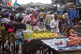 FILE - People buy food at a local market in Monrovia, Liberia.