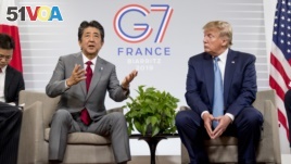 Japanese Prime Minister Shinzo Abe, left, accompanied by U.S President Donald Trump, speaks at a news conference at the G-7 summit in Biarritz, France, Sunday, Aug. 25, 2019, where they announced that the U.S. and Japan have agreed in principle on a new t