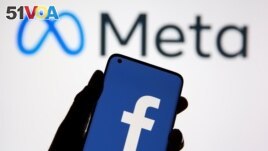 A smartphone with Facebook's logo is seen in front of displayed Facebook's new rebrand logo Meta in this illustration taken Oct. 28, 2021. 