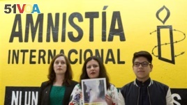 Madeleine Penman, left, Mexico investigator for Amnesty International; Erika Guevara-Rosas, center, Americas Director for Amnesty; center, and Byron Arellano, son of a torture survivor, pose together following a press conference presenting an Amnesty report on female survivors of sexual torture by Mexican authorities, in Mexico City. (AP Photo/Rebecca Blackwell)