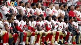 Members of the San Francisco 49ers kneel during the national anthem as others stand during the first half of an NFL football game against the Arizona Cardinals, Oct. 1, 2017, in Glendale, Arizona.