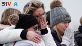Mourners grieve at a memorial at Oxford High School in Oxford, Mich., Wednesday, Dec. 1, 2021. Authorities say a 15-year-old sophomore opened fire at Oxford High School, killing four students and wounding seven other people on Tuesday. (AP Photo/Paul Sancya)