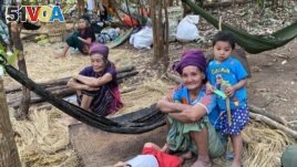 In this photo released by the Free Burma Rangers, ethnic Karen women sit with family members in the jungles of northern Karen State where they are sheltering from an ongoing local offensive by the Myanmar army, on Jan. 27. (Free Burma Rangers via AP)