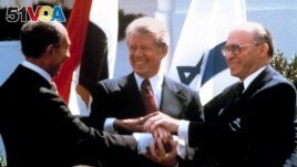 FILE - In this March 26, 1979 file photo, Egyptian President Anwar Sadat, left, U.S. President Jimmy Carter, center, and Israeli Prime Minister Menachem Begin clasp hands as they completed signing of the peace treaty. (AP Photo/Bob Daugherty, File)