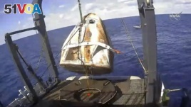 In this March 8, 2019 file image taken from video made available by NASA, the SpaceX Crew Dragon capsule is hoisted onto a ship in the Atlantic Ocean off the Florida coast after it returned from a mission to the International Space Station.