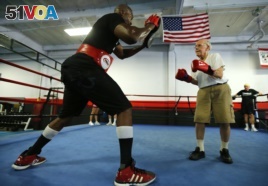 Parkinson's patient Jim Coppula works out in the ring with boxing coach Justice Smith (L) during his Rock Steady Boxing session in Costa Mesa, California September 16, 2013.