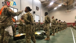 In this image provided by the U.S. Army, recent Army basic combat training graduates have their temperatures taken as they arrive at Fort Lee, Va, on March 31, 2020, after being transported using sterilized buses from Fort Jackson, S.C.