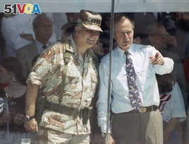 U.S. General Norman Schwarzkopf and then President George H. W. Bush watch the National Victory Parade from the viewing stand in Washington on June 8, 1991.