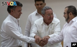 Cuba's President Raul Castro (Center) encourages Colombian President Juan Manuel Santos (Left) and Commander the Revolutionary Armed Forces of Colombia or FARC, Timoleon Jimenez, to shake hands, in Havana, Cuba, Sept. 23, 2015.