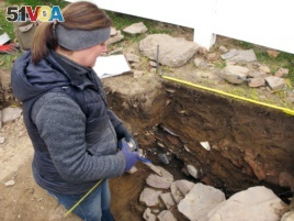 In this Thursday, Nov. 15, 2018, photo archaeologist Sarah Sportman works at a dig site in Wethersfield, Conn.