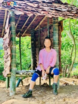 “I never dreamed that I would be sleeping in a roofless shelter or using a makeshift toilet,” said Gue Gue, shown at the toilet she helped build. Source: courtesy of Gue Gue