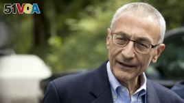 Hillary Clinton campaign chairman John Podesta speaks to members of the media outside Clinton's home in Washington, Oct. 5, 2016.