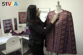 In this Tuesday, January 29, 2019 photo, designer Natalie Tahhan works on a modern version of the traditional Palestinian thobe in her studio in east Jerusalem.
