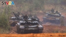 FILE - Russian tanks advance during the Zapad 2017 military exercises near St. Petersburg, Russia, Sept. 18, 2017.
