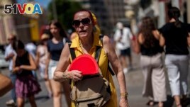 FILE - A woman fans herself in Madrid, Spain, July 10, 2023. Earth last year shattered global annual heat records, the European climate agency said Tuesday, Jan. 9, 2024. (AP Photo/Manu Fernandez, File)