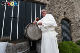 Norbertine Father Karel poses with a Grimbergen beer in the courtyard of the Belgian Abbey of Grimbergen before announcing that the monks will return to brewing, in Grimbergen, Belgium May 21, 2019. REUTERS/Yves Herman