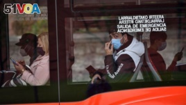FILE - Passengers wearing face masks are seen on a bus in Bilbao, northern Spain, June 12, 2020.
