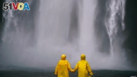 The two people are wearing raincoats over their clothes.