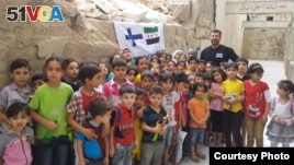 Rami Adham is surrounded by Syrian children who gather near a field school in Aleppo that has since been destroyed, Sept. 2015. (photo courtesy of Rami Adham)