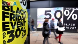 FILE - Shoppers walk past Black Friday signage on Oxford Street in London, Britain, November 23, 2018. (REUTERS/Toby Melville)