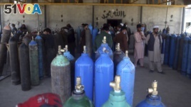 People line up for free oxygen at a privately owned oxygen factory, in Kabul, Afghanistan, Thursday June 18, 2020. For seven years, Najibullah Seddiqi's oxygen factory sat idle in the Afghan capital Kabul.