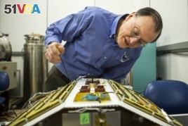 Christopher Ruf, Director of the Space Physics Research Laboratory and Atmospheric, Oceanic and Space Sciences Professor at the University of Michigan, inspects CYGNSS, February 12, 2015.