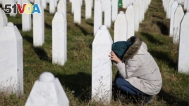 A woman visits a grave of her family members in the memorial center Potocari near Srebrenica, Bosnia and Herzegovina, after the court proceedings of former Bosnian Serb general Ratko Mladic, Nov. 22, 2017.