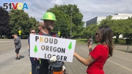 FILE - In this Thursday, June 20, 2019, file photo, a TV reporter interviews self-employed logger Bridger Hasbrouck, of Dallas, Ore., outside the Oregon State House in Salem, Ore.