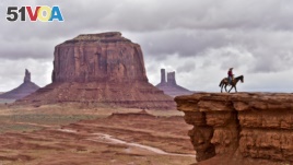 A Navajo man on a horse poses for tourists in front of the Merrick Butte in Monument Valley Navajo Tribal Park, Utah, in May 2015. (AFP PHOTO/MLADEN ANTONOV)