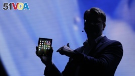 SJustin Denison, SVP of Mobile Product Development, shows off the Infinity Flex Display of a folding smartphone during the keynote address of the Samsung Developer Conference Wednesday, Nov. 7, 2018, in San Francisco. (AP Photo/Eric Risberg)