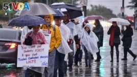 Los Angeles teachers walk on a picket line in pouring rain in front of Los Angeles High School during a city-wide teacher strike on Jan. 14, 2019. 