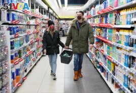 FILE Alexandr Kudlay, 33, and Viktoria Pustovitova, 28, shop at a supermarket in Kharkiv, Ukraine March 5, 2021. Tired of occasional break-ups, this Ukrainian couple found an unusual solution to stay inseparable. On St. Valentine's Day, they decided to handcuff their hands together for three months and began documenting their experience on social media. Picture taken March 5, 2021. REUTERS/Gleb Garanich