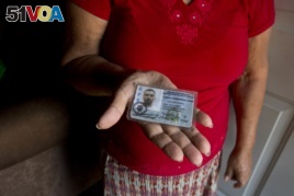 In this Nov. 3, 2018 photo, Haydee Posadas shows the driver's license her son Wilmer Gerardo Nunez was carrying when he was blindfolded and shot dead on his journey north, at her home in Ciudad Planeta neighborhood of San Pedro Sula, Honduras.