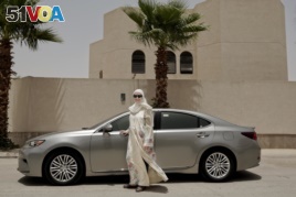 In this Sunday, June 24, 2018 photo, Ammal Farahat, who has signed up to be a driver for Careem, a regional ride-hailing service that is a competitor to Uber, poses for a photograph next to her car on a street in Riyadh, Saudi Arabia.