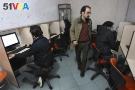 FILE- In this Tuesday, Jan. 18, 2011 file photo, Iranians work in an internet cafe in central Tehran, Iran. In Iran, a government push for a 'halal' internet means more control after protests. (AP Photo/Vahid Salemi, File)