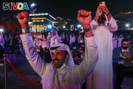 People react as they watch screens displaying information of the Hope Probe entering the orbit of Mars, in Dubai, United Arab Emirates, February 9, 2021. (REUTERS/Christopher Pike)