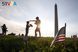 Rowan McManus, 10, directs his sister Fiona McManus, 5, as they help to remove 5,000 small U.S. flags representing suicides of active and veteran members of the military line the National Mall, Wednesday, Oct. 3, 2018.