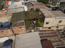In this Jan.10, 2020 photo, Luis Cassiano shows his green roof at his home in Arara Park favela, Rio de Janeiro, Brazil. 