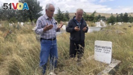 Adem Karaagac, left, and Satilmis Karatekin pray at the grave of a distant relative of Boris Johnson, in Kalfat, a village in the Cankiri province, 100 kilometers (62 miles) north of the Turkish capital Ankara, Turkey, July 25, 2019.