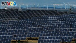 FILE - Solar panels and windmills work near the small town of Milagro, Navarra Province, northern Spain, Feb. 24, 2023. (AP Photo/Alvaro Barrientos, File)