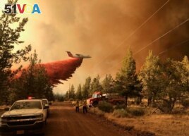 This photo provided by the Oregon Department of Forestry shows a firefighting tanker dropping fire-fighting materials over the Grandview Fire near Sisters, Oregon, July 11, 2021. (AP Photo)