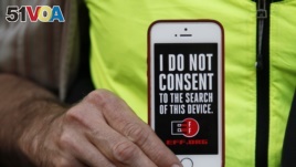 In this file photo, a man holds up his iPhone during a rally in support of data privacy outside the Apple Store in San Francisco, Feb. 23, 2016.