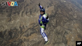 In this Monday, July 25, 2016 photo, skydiver Luke Aikins smiles as he jumps from a helicopter during his training in Simi Valley, Calif. 