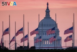 Flags flying a half-staff in honor of Sen. John McCain, R-Ariz., frame the U.S. Capital at daybreak in Washington, Aug. 26, 2018.