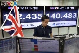 A monitor (R) displays the current exchange rate of the Japanese yen against the British Pound as a trader works at a foreign exchange brokerage in Tokyo, Japan, 24 June 2016.