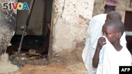 A child covers his nose inside a mosque where a suicide bomber killed over 20 worshipers in Maiduguri, Sept. 21, 2015.