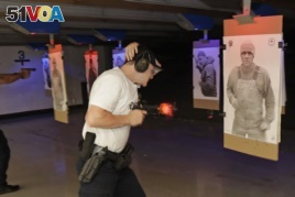 FILE: An officer at Washington state's Law Enforcement Academy fires his weapon as a photo of man not holding a weapon moves into view during a training class in Burien, Wash. July 16, 2019.