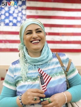 This September 2019 provided by Danielle Luna shows Iraqi born refugee Nada Al Rubaye at her naturalization ceremony in Phoenix. The artist left Baghdad after one of her sons and several other relatives were killed in the widespread violence.