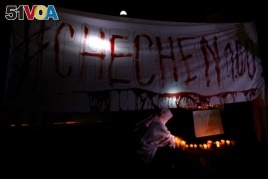 Activists from the group Chok3 paint a banner with their own blood during a protest discrimination and violence against the gay community in Chechnya and other regions of Russia, outside the Russian embassy in Mexico City, Mexico, April 20, 2017.